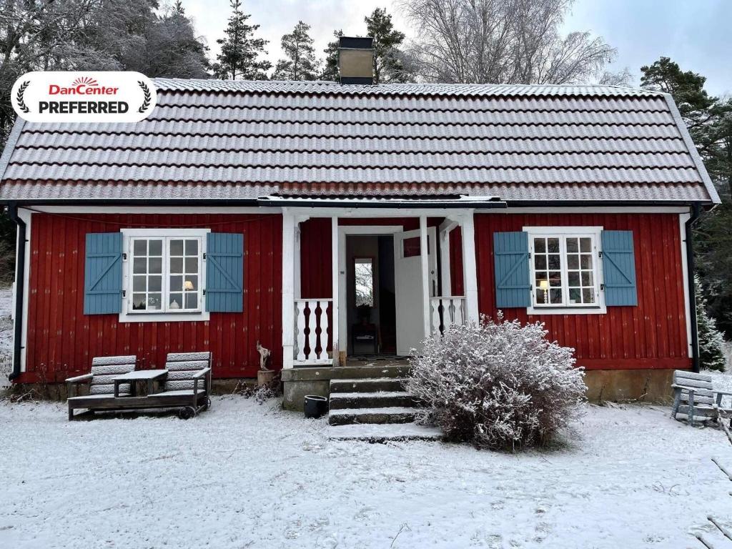una casa roja con nieve en el suelo delante en 6 person holiday home in JÄRNA-By Traum, en Järna