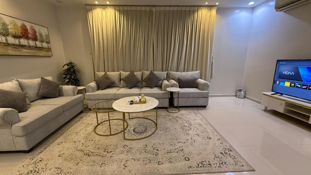 a living room with a couch and a tv at شقق العارض (2) in Riyadh