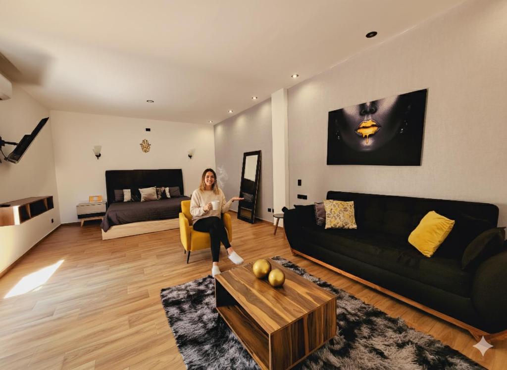 a woman is sitting in a living room at Suite Tlaquepaque centro in Guadalajara