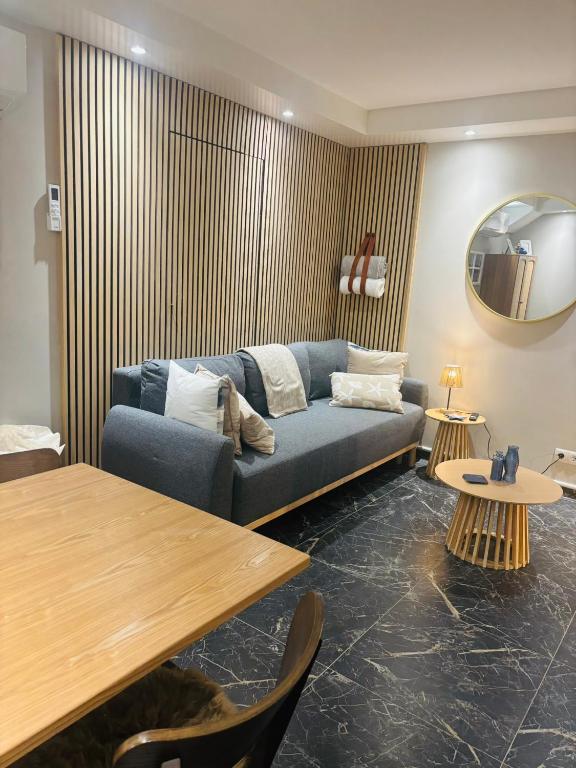 a living room with a blue couch and a table at Duin 10 in Katwijk aan Zee