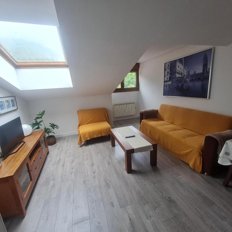a living room with a couch and a table at Ático Felechosa loft in Felechosa