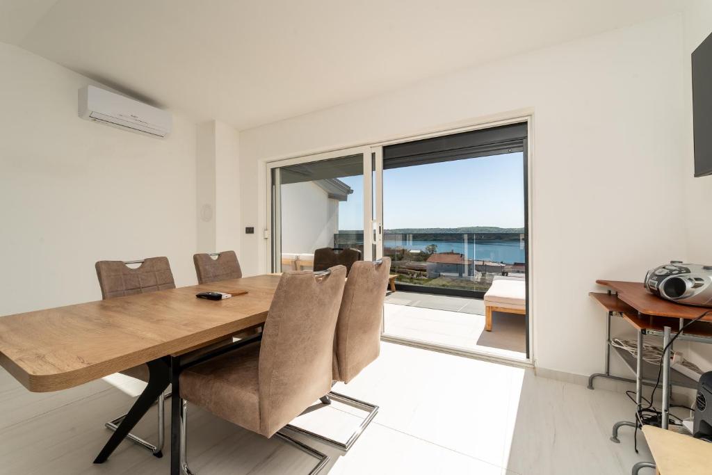 a dining room with a wooden table and chairs at Seaview Villa Summer with private pool & garden in Rtina