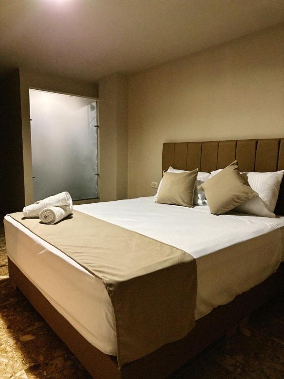 リオネグロにあるHotel Bossanovaの白いシーツと枕が付いた大きなベッドのある寝室