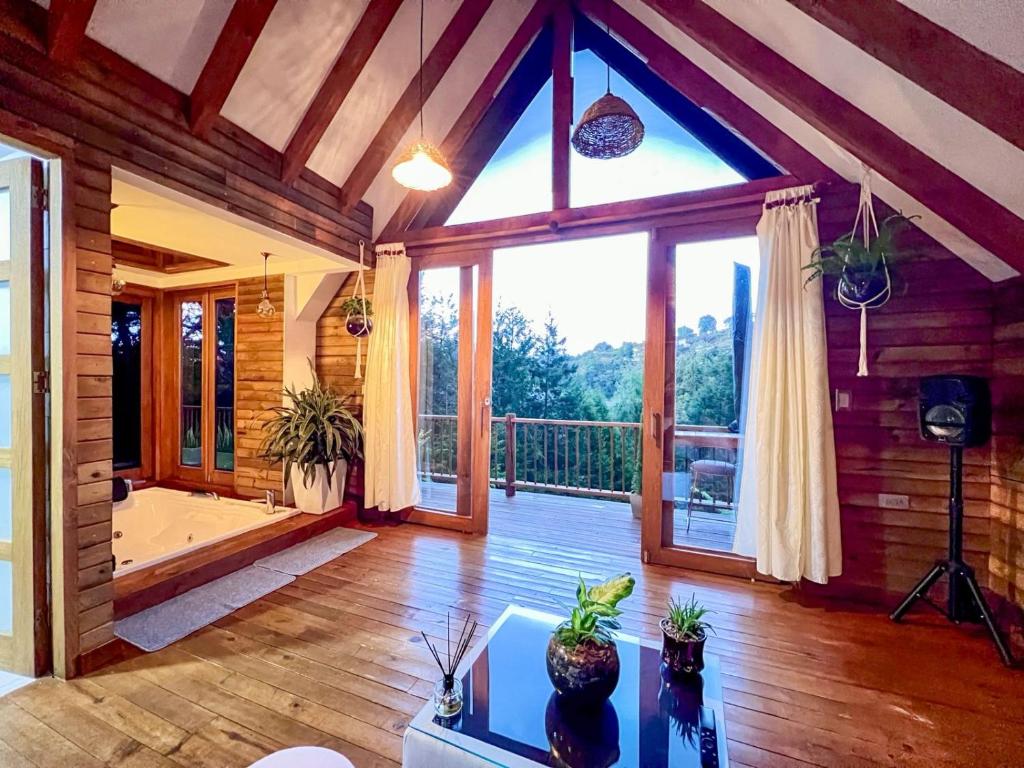 sala de estar con ventana grande y bañera en Chalet Boutique a 7 Min del Aeropuerto JMC, en Guarne