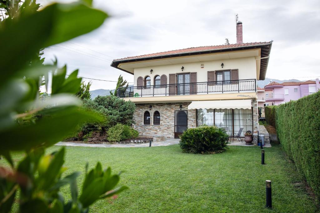 Una casa con un césped verde delante de ella. en Olympus Leptokaria’s Luxurious Villa, en Leptokarya