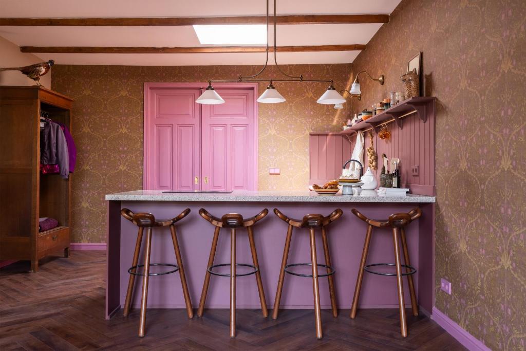 a kitchen with a purple island with bar stools at Luxurious vintage loft near city center in Groningen