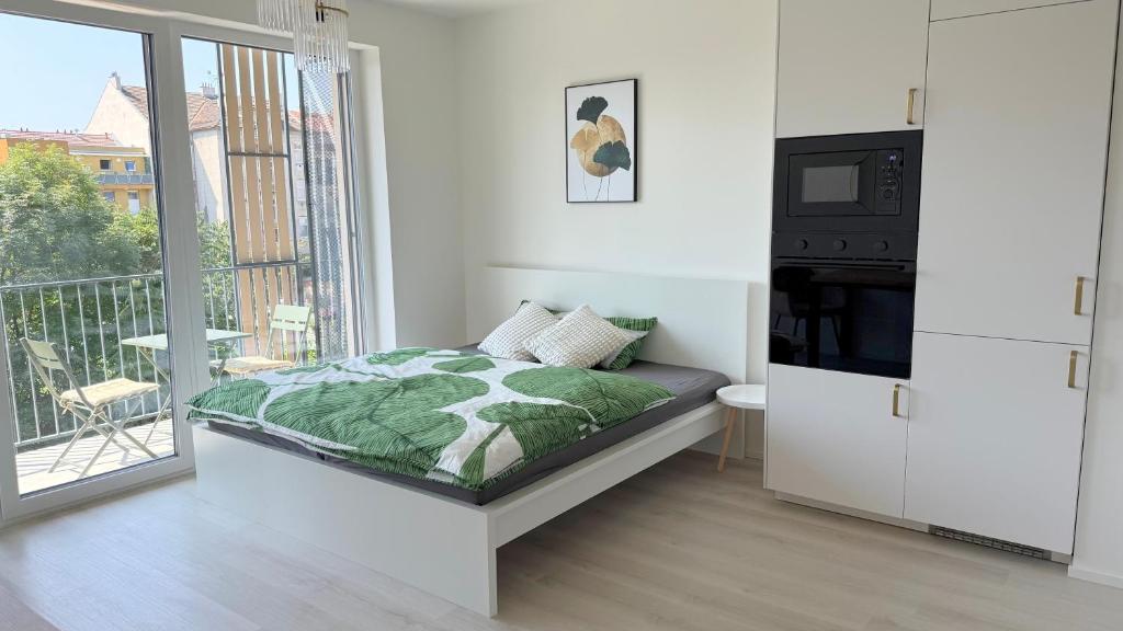 Un dormitorio con una cama con televisión y un balcón. en Kijani - apartment the station, en Komárov