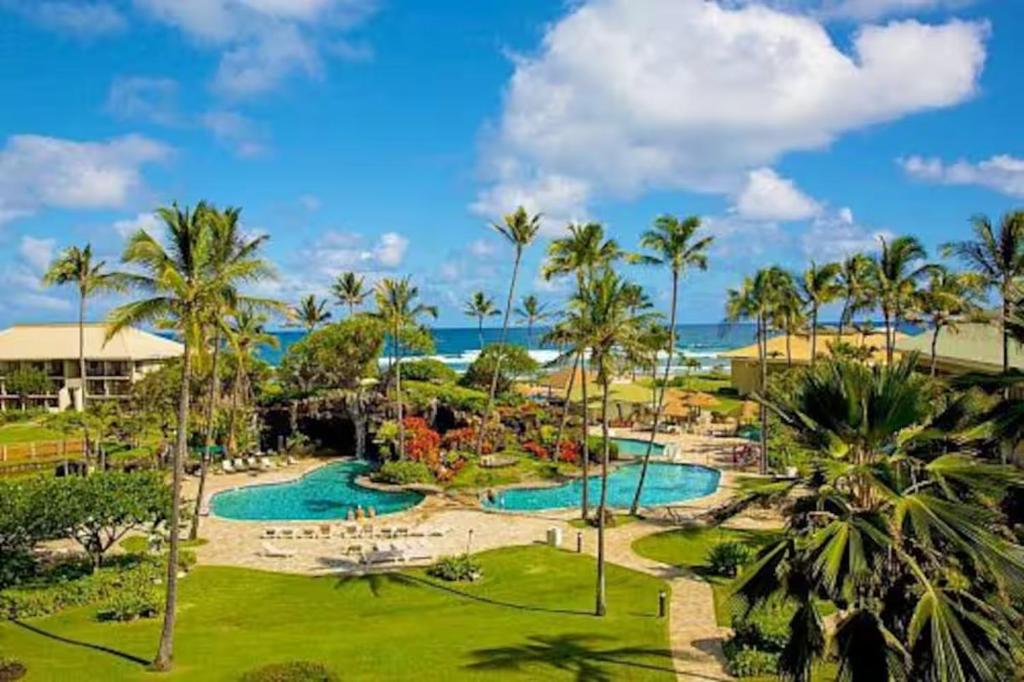 ein Resort mit 2 Pools und Palmen in der Unterkunft Kauai Dreams Escape II in Lihue
