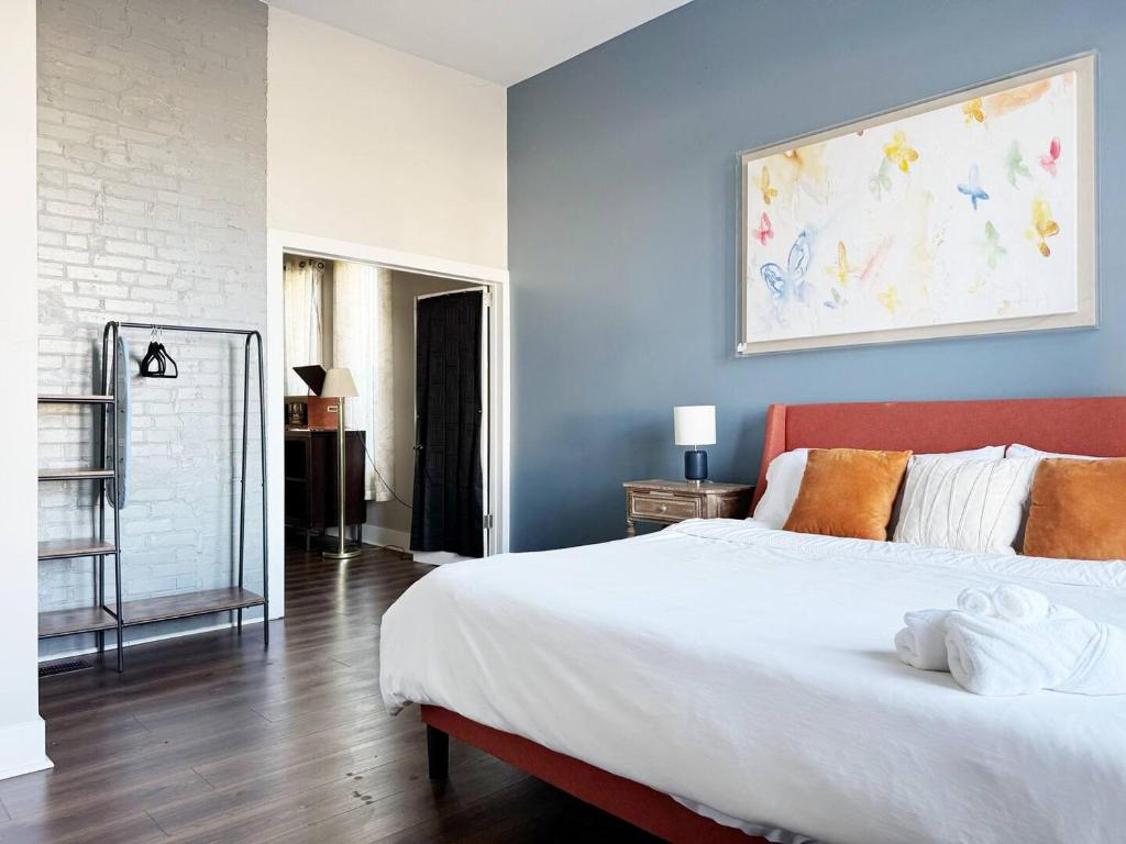 a bedroom with a large bed and a painting on the wall at The Washington Apartments in Evansville