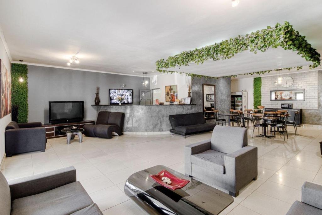 ヨハネスブルグにあるHunni Hotel Melrose Edgeのソファとテレビ付きの広いリビングルーム