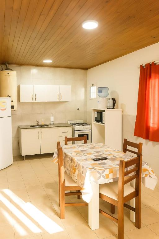 a kitchen with a table and chairs and a refrigerator at Departamento ITATI in General Alvear