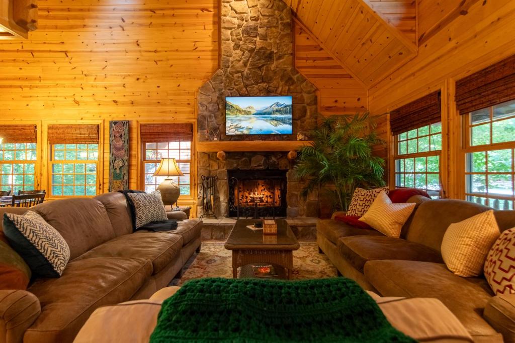 een woonkamer met banken en een open haard bij Cedarwood Lodge in Saugatuck