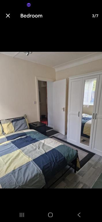 a bedroom with a bed and a large window at Andrea house in Thornton Heath