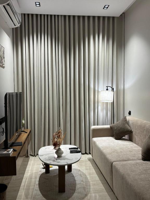 a living room with a couch and a coffee table at شقة غرفة وصاله - حي البرج in Al Kharj