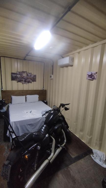 a motorcycle parked in a room with a bed at MOTO Inn URUBICI in Urubici