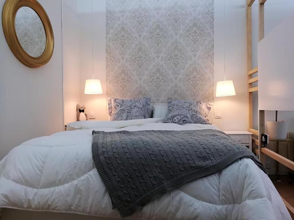 a bedroom with a large bed and a mirror at Loft Nórdico Madrid Aguilafuente in Madrid