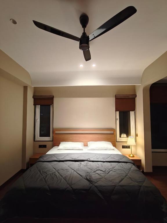 a bedroom with a bed with a ceiling fan at Evara - stay explore belong in Varanasi