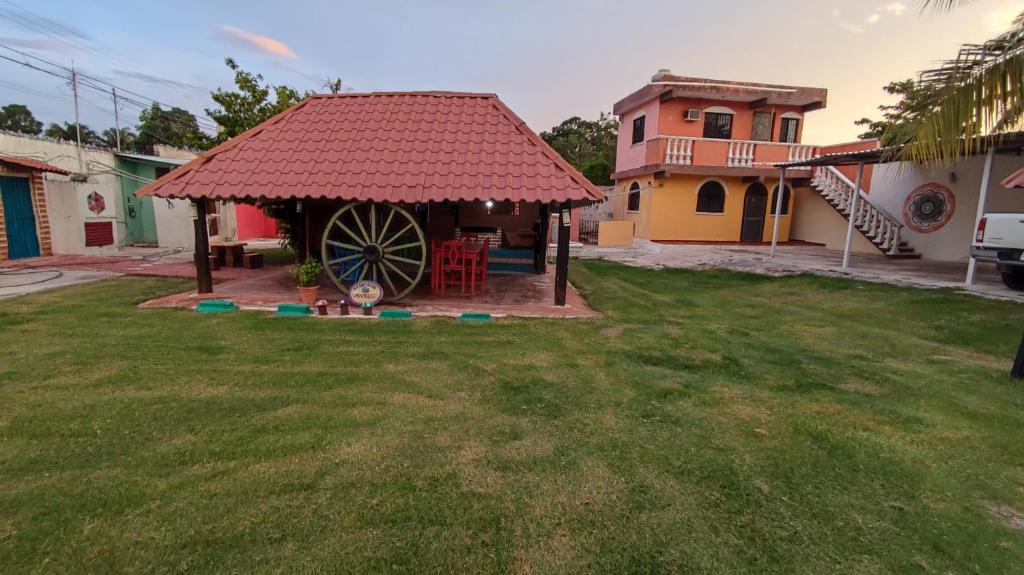 a gazebo with a large wheel in a yard at Las Villas Champoton in Champotón