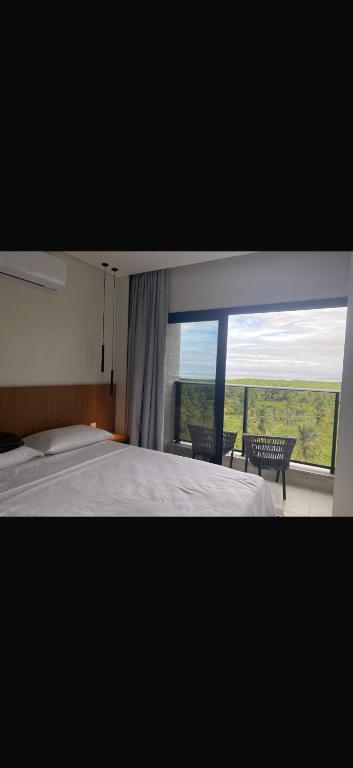 a bedroom with a bed and a large window at Gav resort in Salinópolis