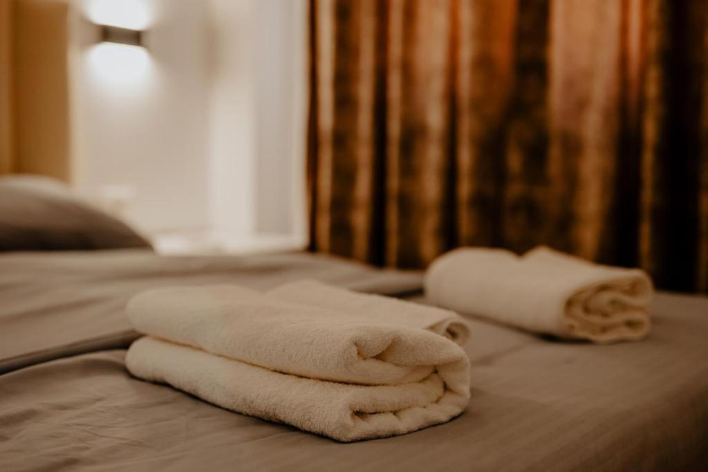 ティラナにあるHotel Suite Dolce Vitaのベッドに座るタオル