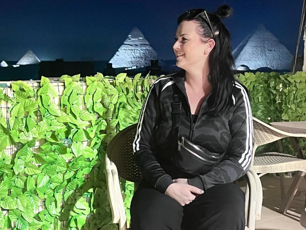 a woman sitting in a chair in front of plants at Relax pyramids view in Cairo