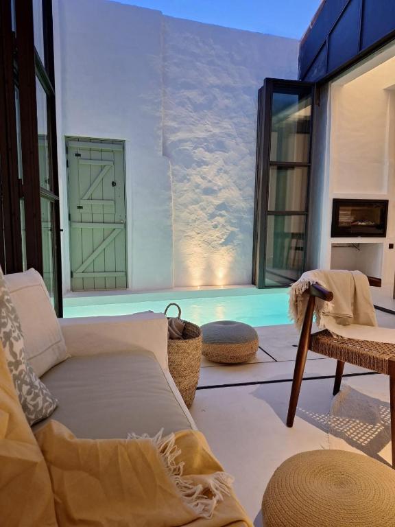 a living room with a couch and a large window at Casa do Capitão in Monte Trigo