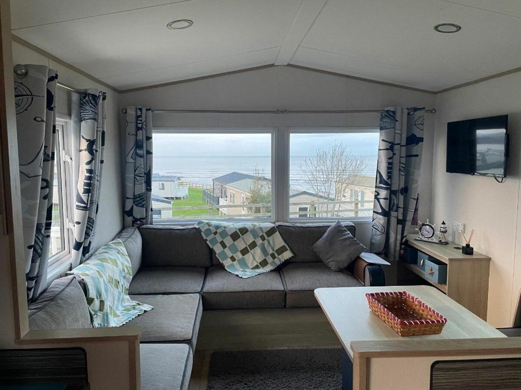 un salon avec un canapé et une grande fenêtre dans l'établissement Doniford Bay - Holiday Accommodation 20985, à Watchet