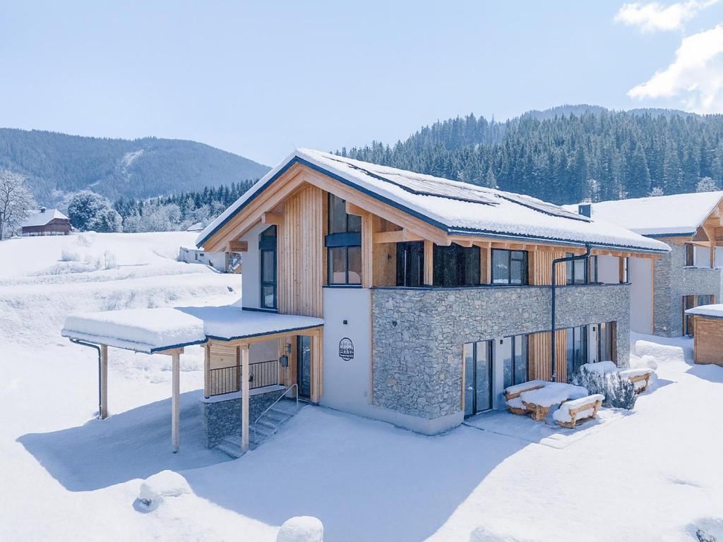 a house in the snow with snow on the roof at Almchalet Alpenglück in Sankt Lambrecht