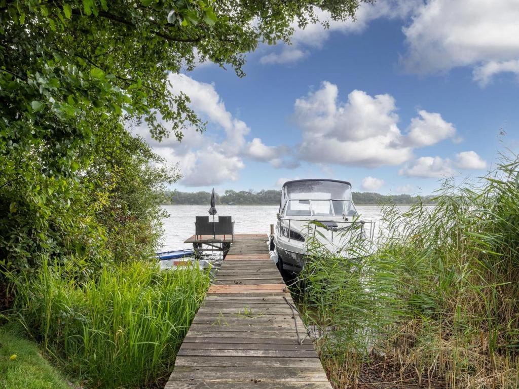 a boat is parked on a dock next to the water at Nelsen mit Ruderboot auf Wassergrundstück in Jabel
