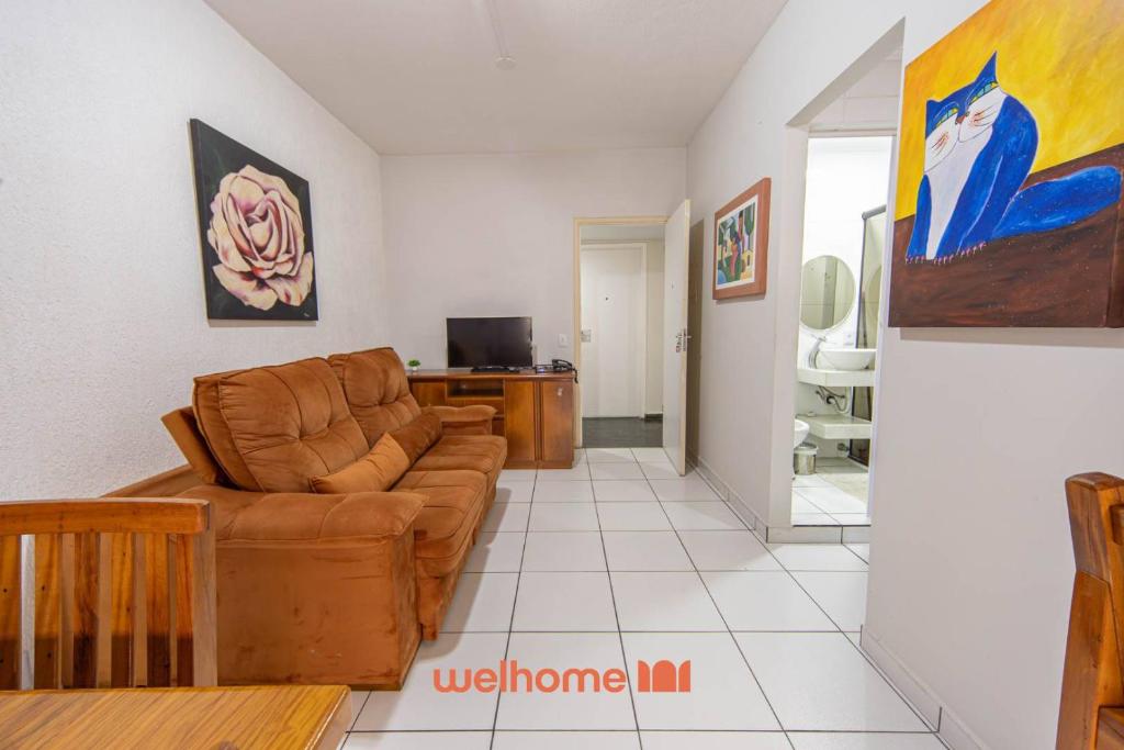 グアルジャにあるApartamento em Guarujá próximo ao Shopping La Plageのソファとテレビのあるリビングルーム