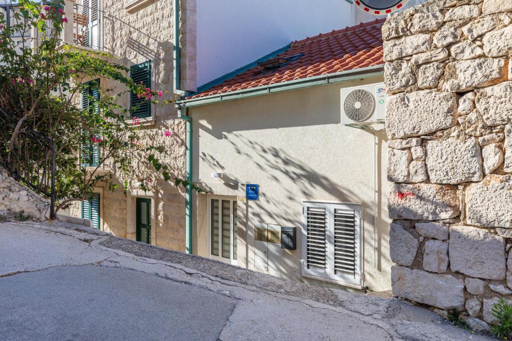 a building with a window and a stone wall at Apartments by the sea Drasnice, Makarska - 23854 in Drašnice