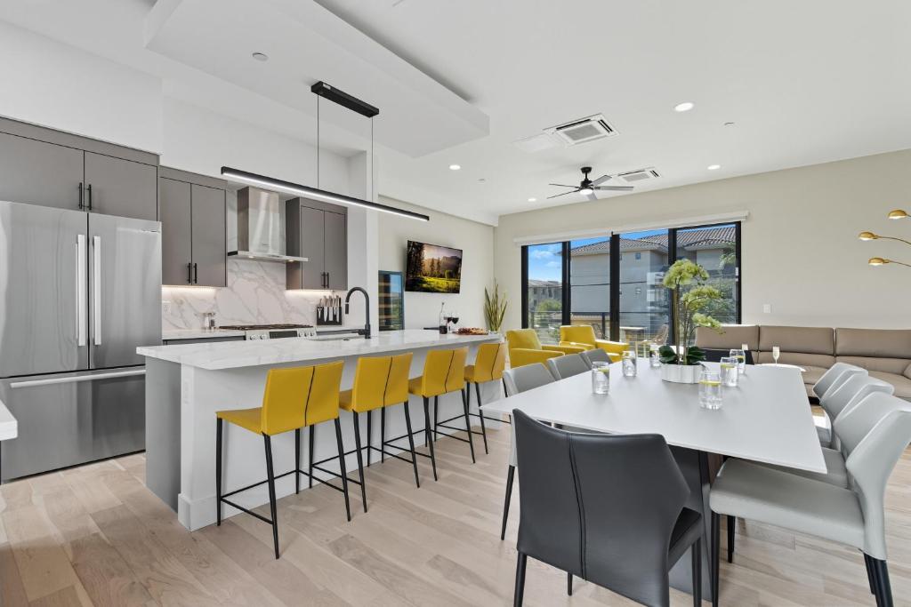 a kitchen and dining room with a table and yellow chairs at Scottsdale - 1501 N Miller Rd #1015 in Scottsdale