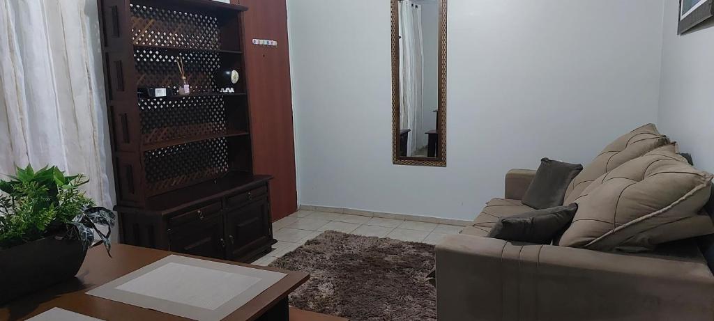 a living room with a couch and a mirror at Quarto individual em apto aconchegante in Sao Jose do Rio Preto