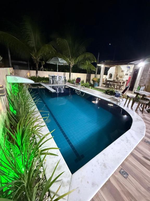 a swimming pool in a resort at night at Meu Aconchego in Tamandaré