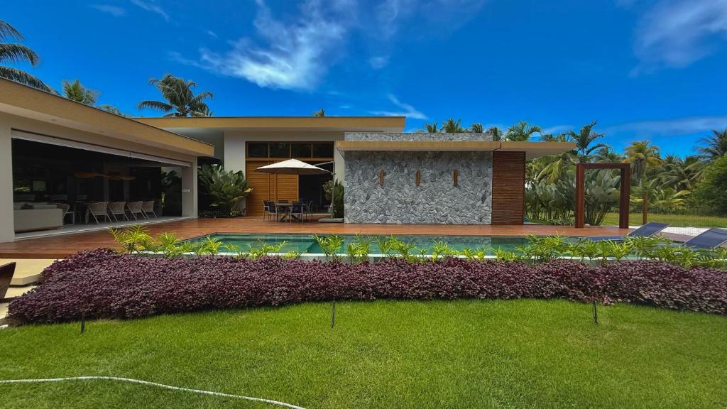 a house with a yard with a swimming pool at Casa Varandas Morro de São Paulo in Cayru