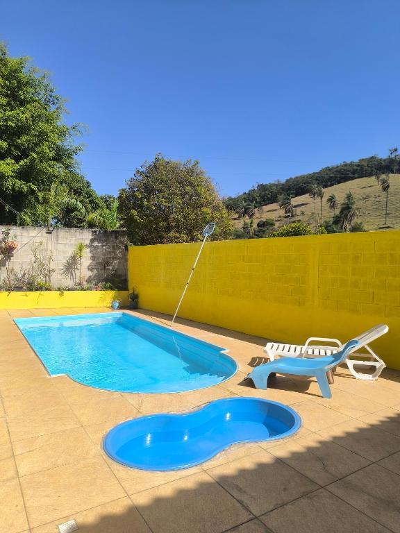 a swimming pool with a bench and a water hose at Sítio vida boa - Jambreiro in Itabira