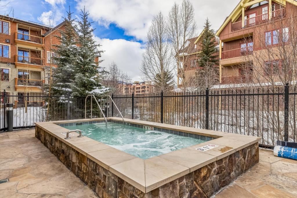 a hot tub in a patio with a fence at Cozy Winter Escape - 2BR & 2BA Near Snowy Trails and Downtown in Breckenridge