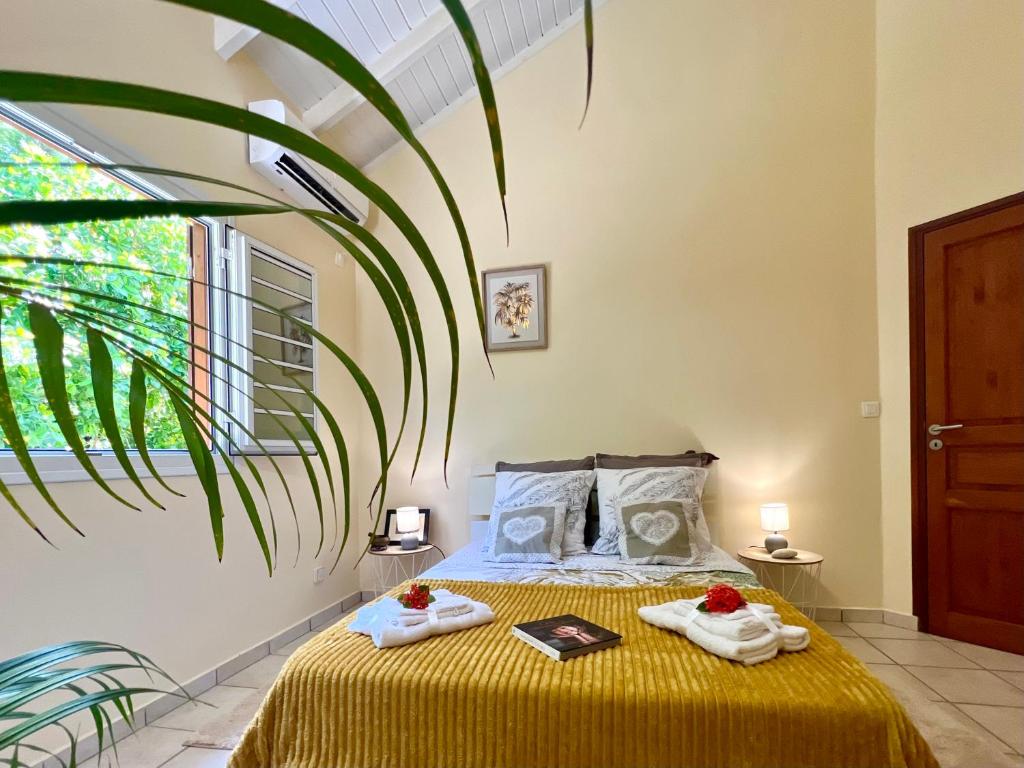 a bedroom with a bed with two towels on it at Kaz a Doudou La in Saint-François