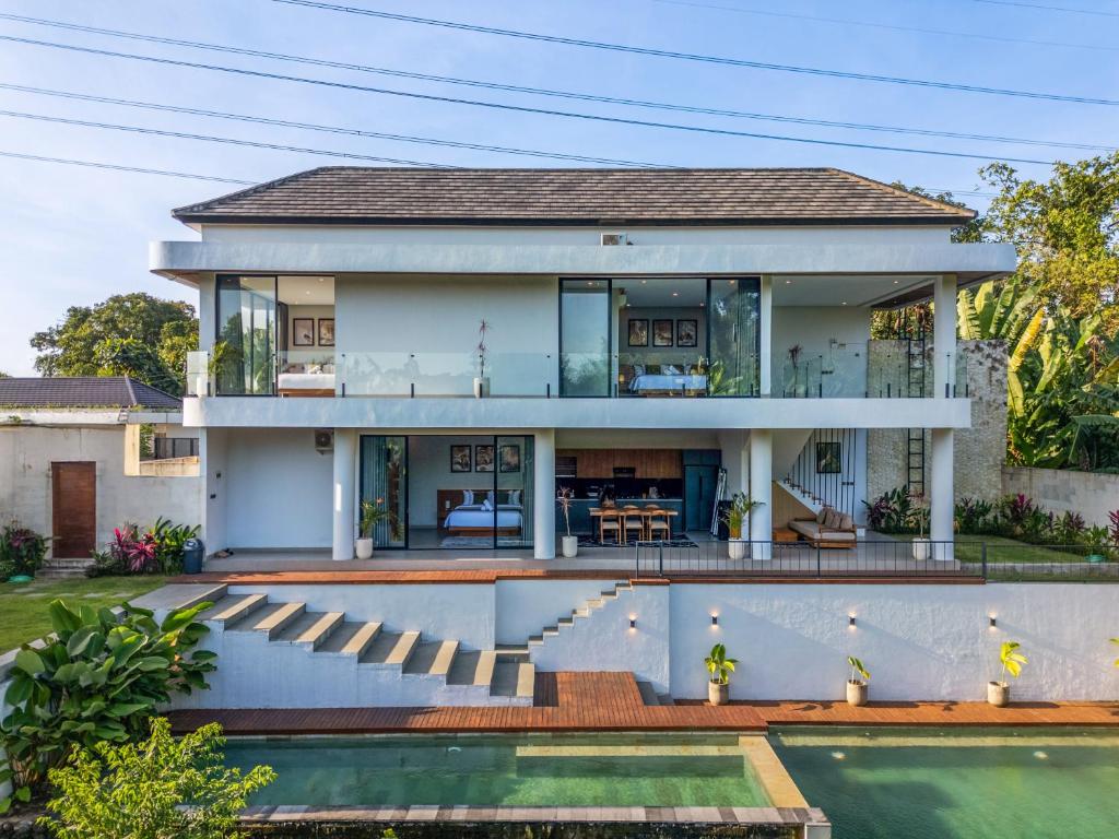a house with a pool in front of it at Jungle Breeze Villa by Betterplace in Tumbak Bayuh