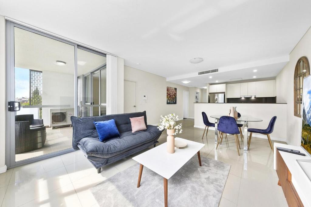 シドニーにある2BR APT Ideal for Families or Business Staysのソファとテーブルのあるリビングルーム