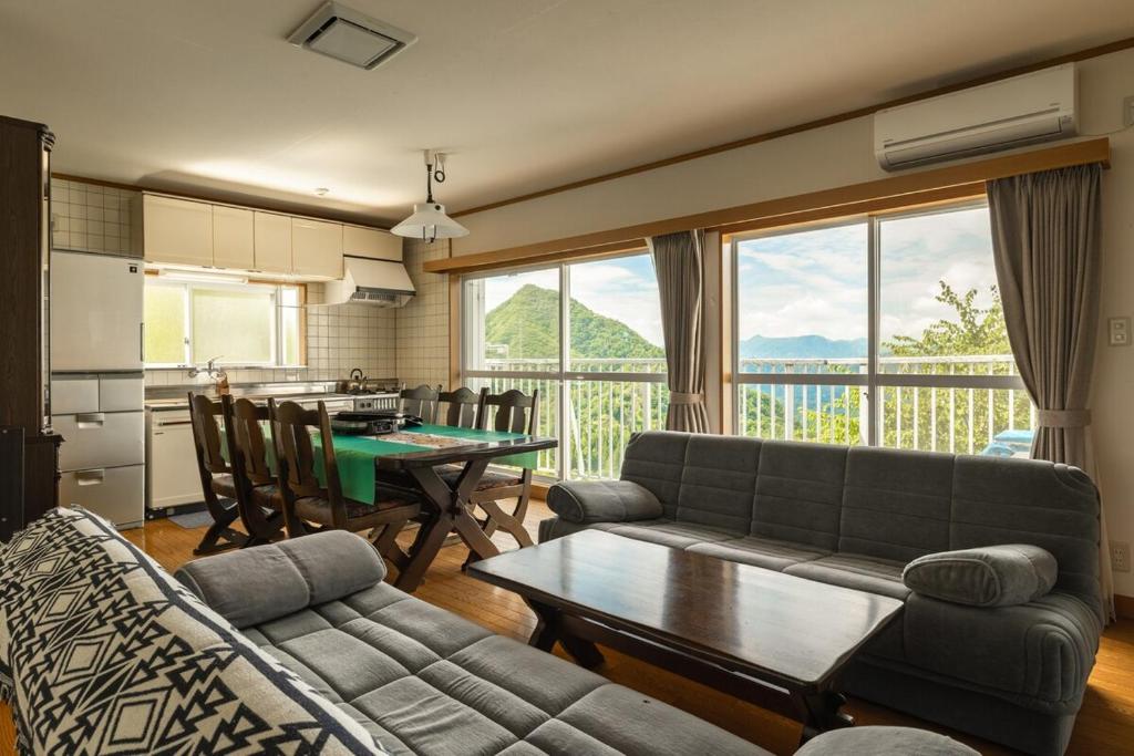 a living room with a couch and a table at 軽井沢 デッキからの眺望 BBq カラオケ IC下車5分 in Karuizawa