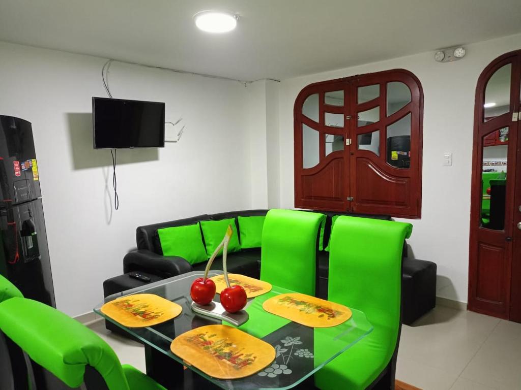 un soggiorno con sedie verdi e tavolo di Valdy hause 202 a Gaira