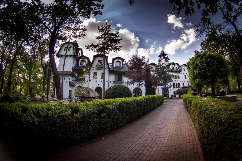 a large white house with a brick road in front at Hotel Maria in Strzelin