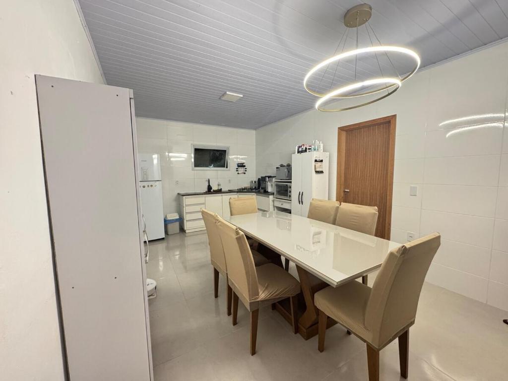 ein Esszimmer mit einem weißen Tisch und Stühlen in der Unterkunft Casa para temporada em Garopaba in Garopaba