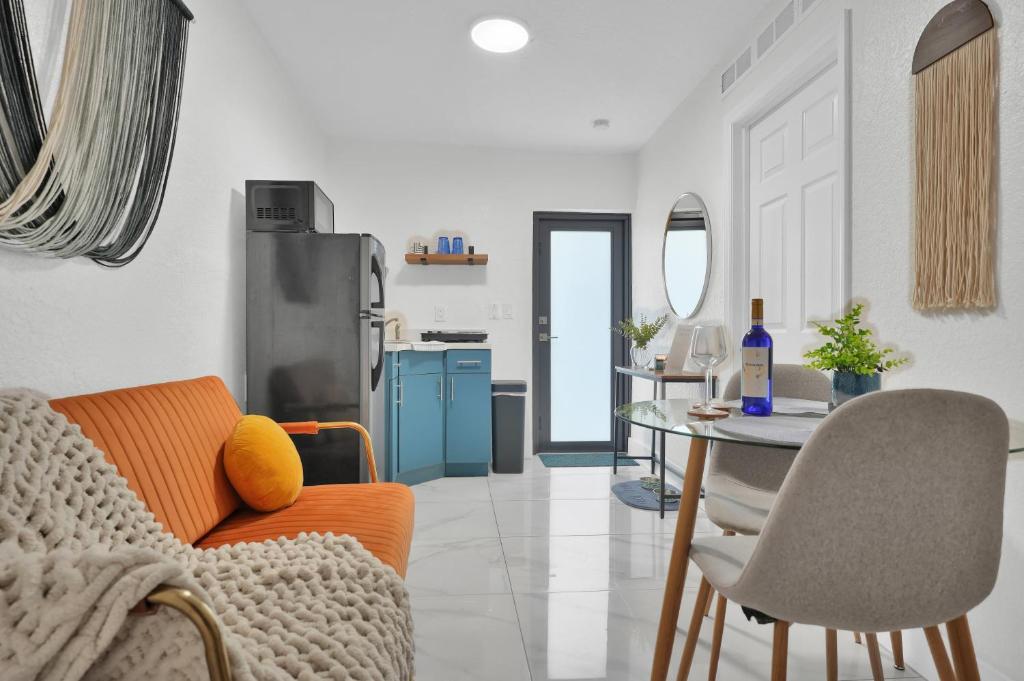 a living room with an orange couch and a table at Suite Azul Miami - Private Guest Suite with Patio, Free Parking, Near Wynwood and Beaches in Miami