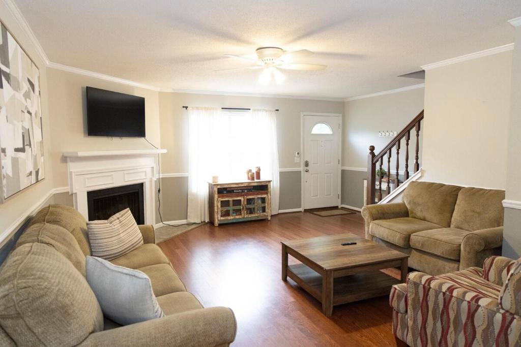 a living room with a couch and a fireplace at 2 Bedroom Townhouse Retreat 10 min to UA Stadium in Tuscaloosa