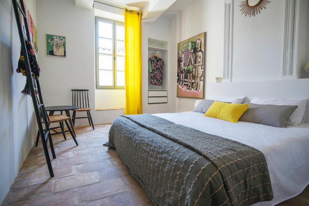 a bedroom with a bed and a table and a window at Les Toiles du 15 in Montaren-et-Saint-Médiers
