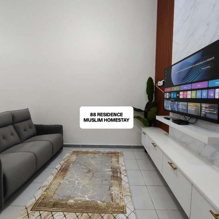 a living room with a couch and a tv at 88 Residence Homestay Musleem in Jitra