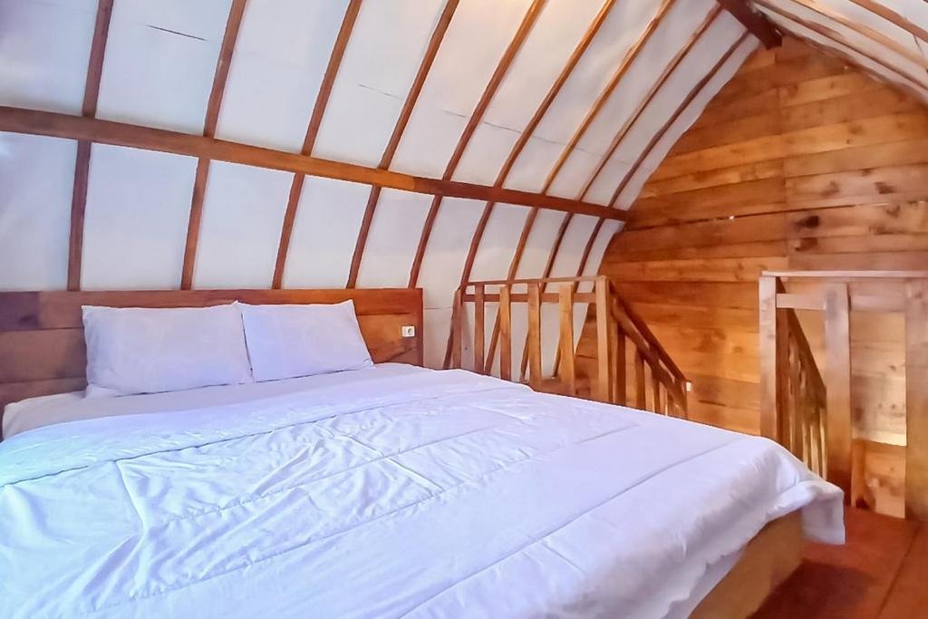 1 dormitorio con 1 cama blanca en el ático en Griya Cabin 2 Dieng Syariah RedPartner, en Diyeng