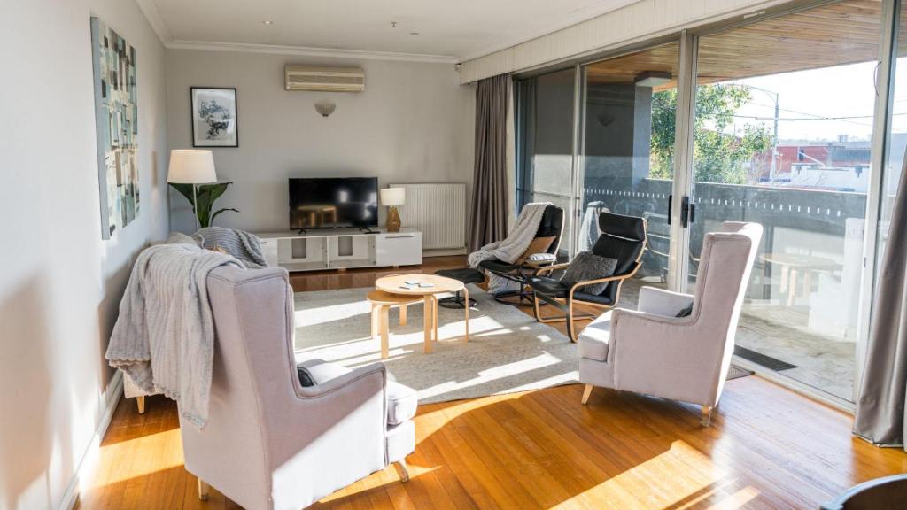 un soggiorno con sedie, tavolo e TV di Prime Location Private Home Large Pool Pets welcome a Glen Iris